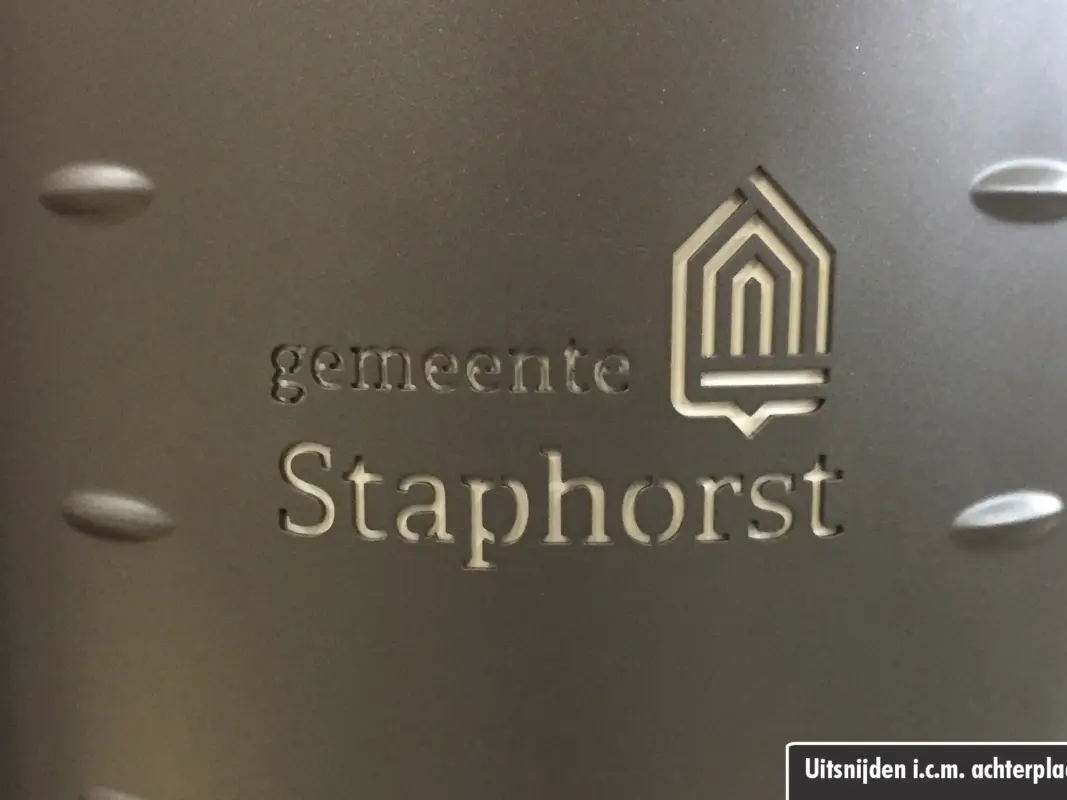 Uitgesneden logo in deurpaneel van de afvalbak