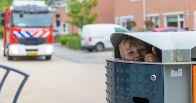 Jongen opgesloten in prullenbak op straat - Straatmeubilair van Grijsen Park en Straatdesign