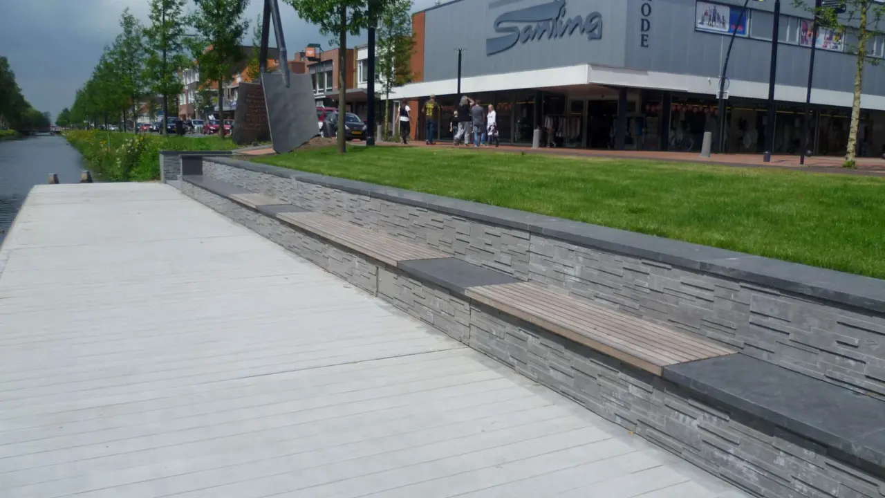 Kaimauer mit Holzsitzauflagen Dorfzentrum Stadskanaal